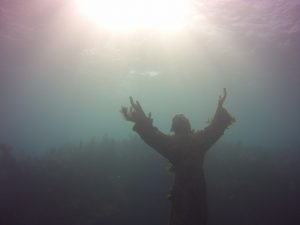 Statue of Christ of the Abyss stretching up to the sunlight